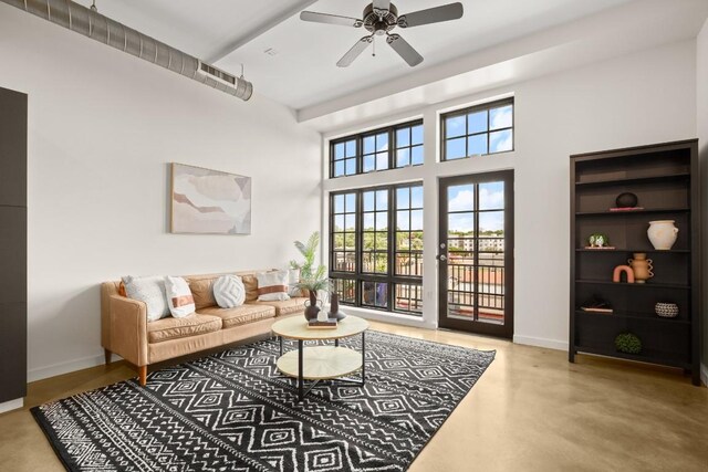 living room with concrete floors, built in features, and ceiling fan