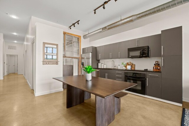 kitchen featuring a breakfast bar, sink, and black appliances