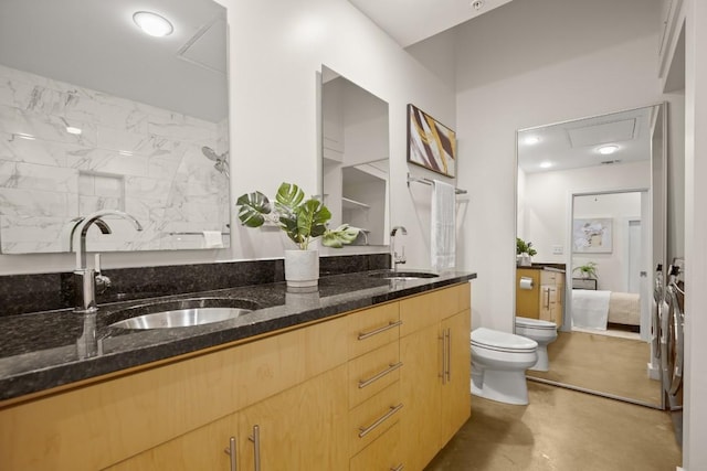 bathroom featuring concrete flooring, double vanity, a sink, and toilet