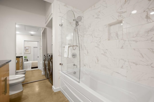 full bathroom with washing machine and dryer, concrete floors, toilet, vanity, and tiled shower / bath