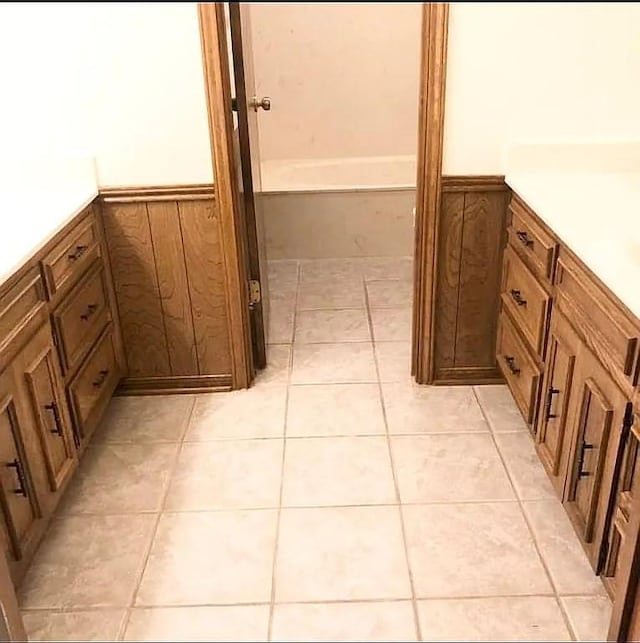 bathroom featuring tile patterned flooring, vanity, and wood walls