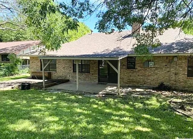 rear view of house with a yard and a patio