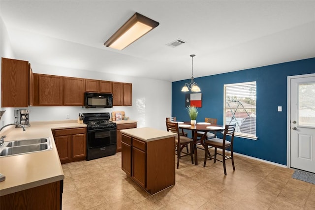 kitchen featuring sink, hanging light fixtures, a chandelier, a kitchen island, and black appliances