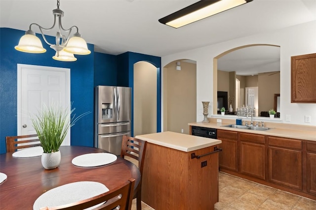 kitchen with pendant lighting, sink, a notable chandelier, a kitchen island, and stainless steel fridge with ice dispenser