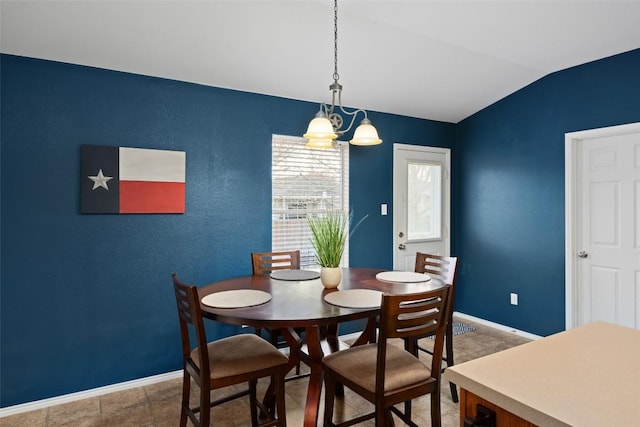 dining space featuring lofted ceiling and an inviting chandelier