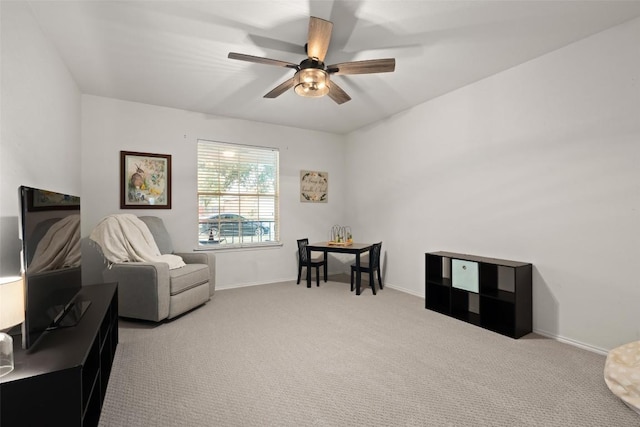 living area with light carpet and ceiling fan