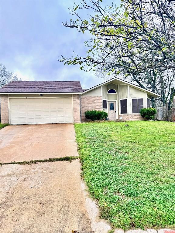 ranch-style house featuring a garage and a front lawn