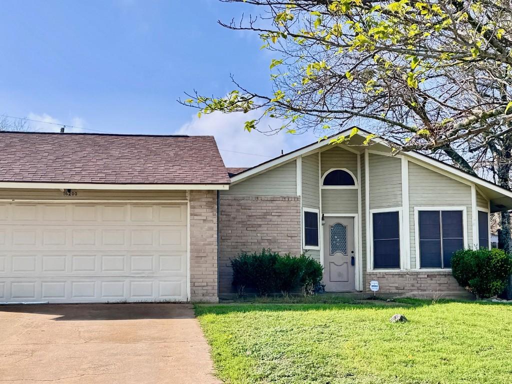 view of front of property featuring a front yard and a garage