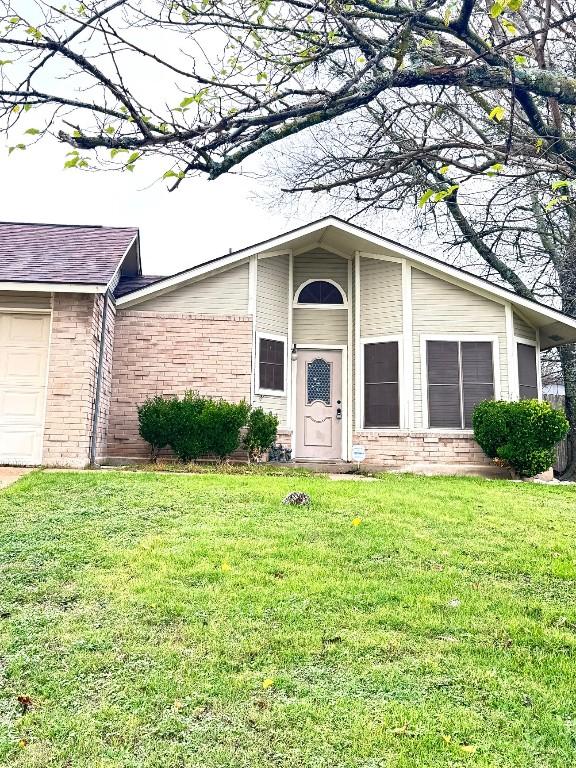 property entrance with a lawn and a garage