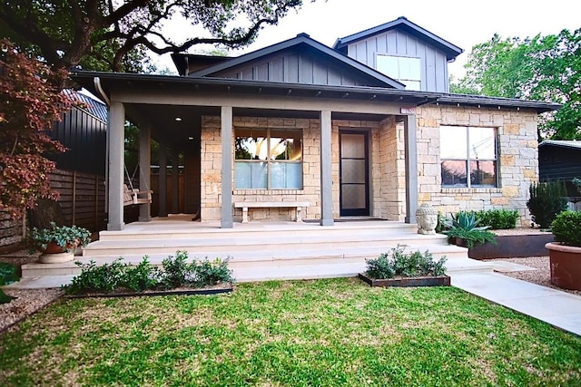 view of front of property with covered porch and a front yard