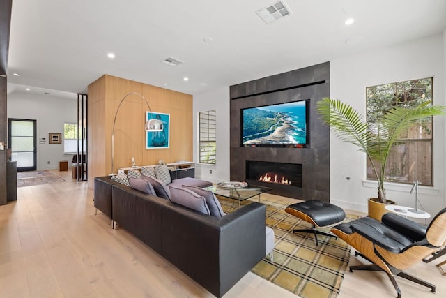 1005 Jewell St, Austin, TX 78704 - living room featuring recessed lighting, a tiled fireplace, healthy amount of natural light, and light wood-type flooring