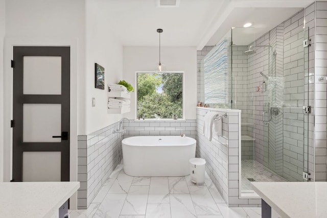 1005 Jewell St, Austin, TX 78704 - full bath with a soaking tub, a shower stall, vanity, wainscoting, and marble finish floors