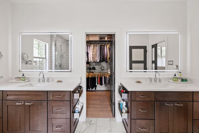 1005 Jewell St, Austin, TX 78704 - full bathroom featuring two vanities, marble finish flooring, a spacious closet, and tiled shower