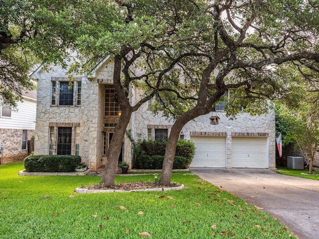 view of front of house with a garage, central air condition unit, and a front yard