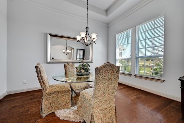 dining area with a notable chandelier, ornamental molding, and dark wood-type flooring