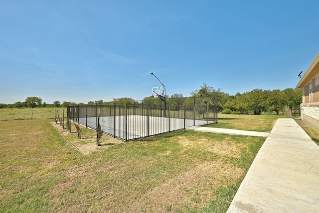 view of sport court featuring a lawn