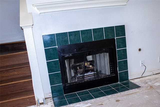 interior details featuring a tile fireplace