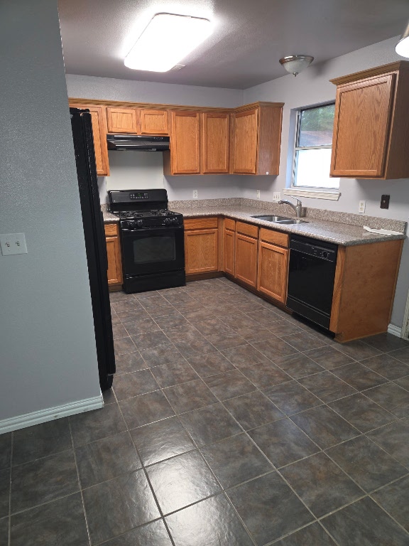 700 N Faircrest Dr, Buda, TX 78610 - kitchen featuring black appliances, a sink, range hood, brown cabinets, and baseboards