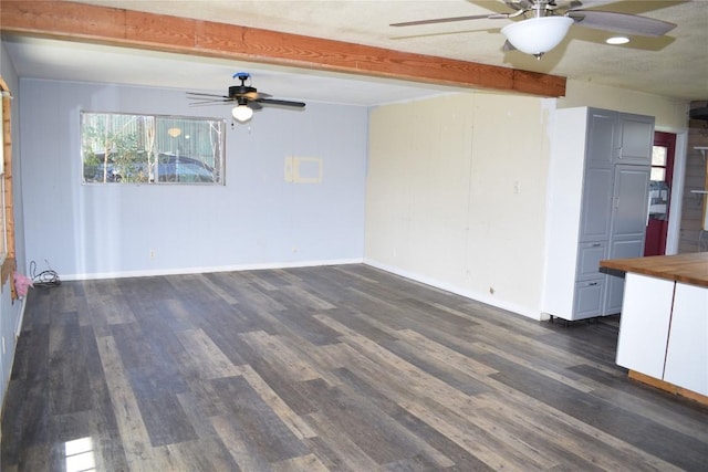 spare room featuring dark hardwood / wood-style floors and beam ceiling