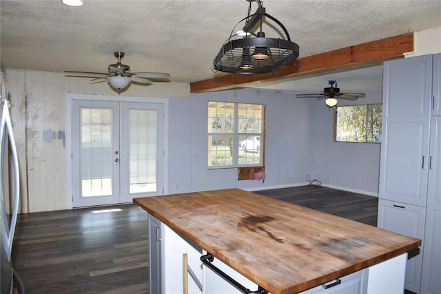 kitchen with french doors, pendant lighting, butcher block countertops, white cabinetry, and plenty of natural light