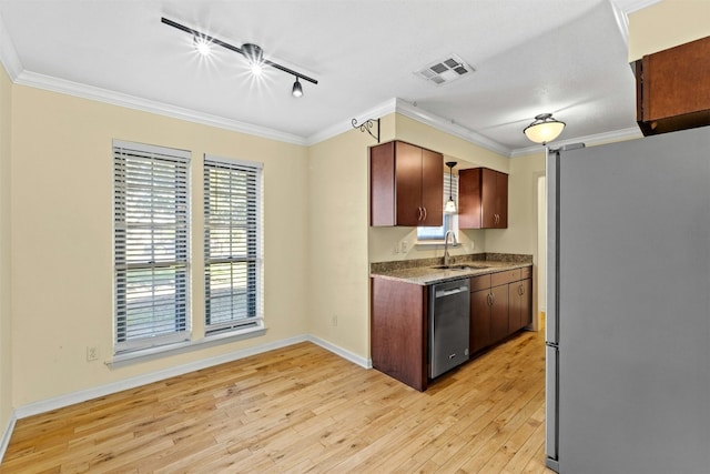 104 Thompson St, Cedar Park, TX 78613 - kitchen featuring stainless steel appliances, light wood-style flooring, ornamental molding, rail lighting, and healthy amount of natural light