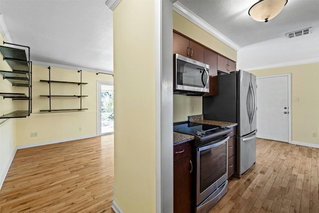 kitchen with light wood-type flooring, dark brown cabinets, a textured ceiling, stainless steel appliances, and crown molding