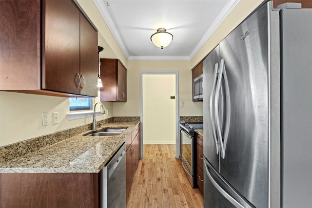 104 Thompson St, Cedar Park, TX 78613 - kitchen featuring stainless steel appliances, light wood-type flooring, ornamental molding, and light stone countertops