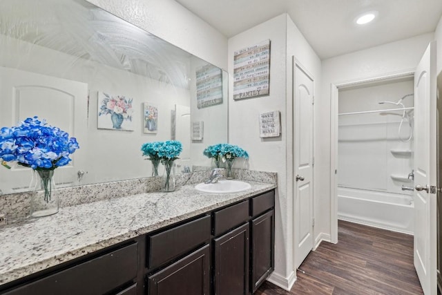 bathroom featuring shower / bathtub combination, hardwood / wood-style floors, and vanity