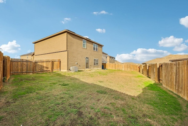 back of house featuring cooling unit and a yard