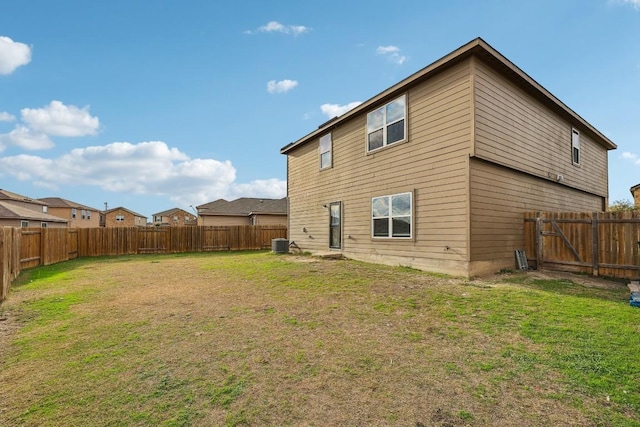 back of property with cooling unit and a lawn