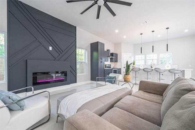 living room with ceiling fan and a fireplace