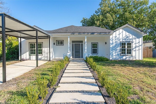 view of front of house with a carport, covered porch, and a front yard