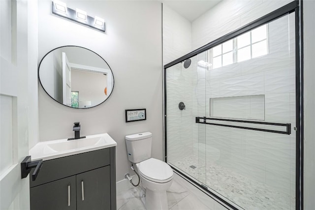 bathroom featuring vanity, toilet, and a shower with door