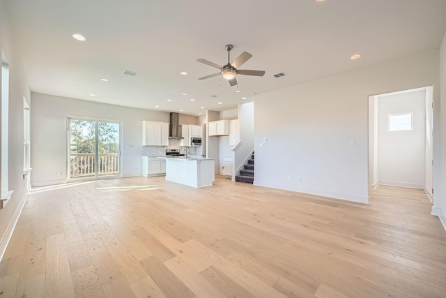 unfurnished living room featuring ceiling fan and light hardwood / wood-style flooring