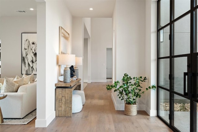 hall with expansive windows and light hardwood / wood-style floors