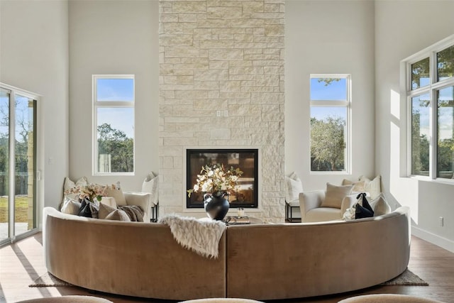 interior space featuring hardwood / wood-style floors, a towering ceiling, and a fireplace