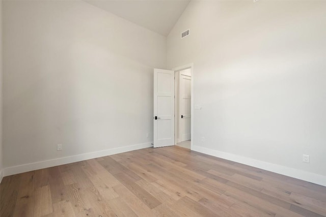 unfurnished room featuring high vaulted ceiling and light hardwood / wood-style flooring