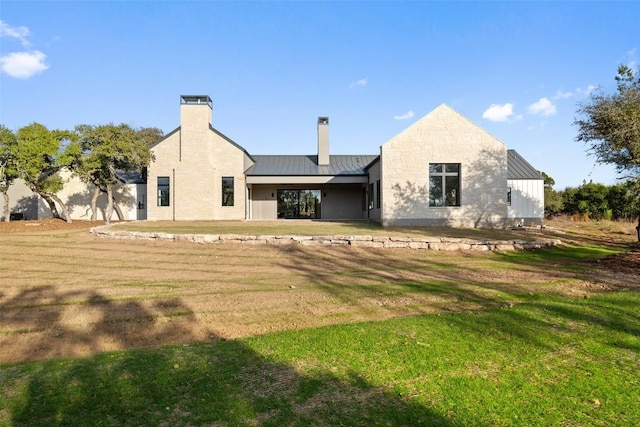 rear view of house featuring a yard