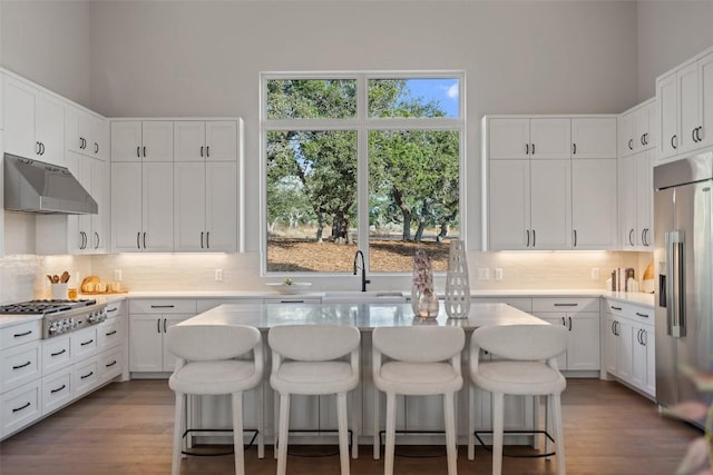 kitchen with white cabinetry, a breakfast bar area, stainless steel appliances, and a center island