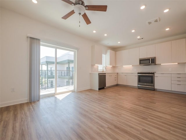 kitchen featuring ceiling fan, decorative backsplash, light hardwood / wood-style floors, white cabinetry, and stainless steel appliances