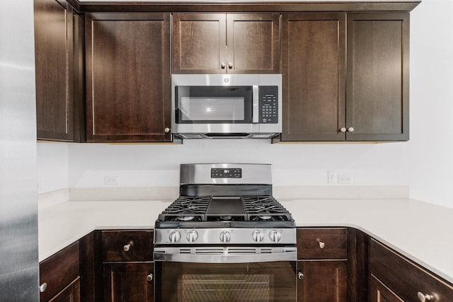 kitchen with dark brown cabinetry and appliances with stainless steel finishes