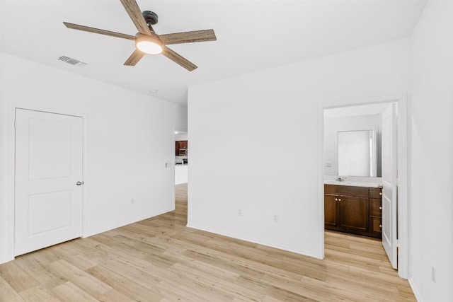 spare room with light hardwood / wood-style floors, ceiling fan, and sink