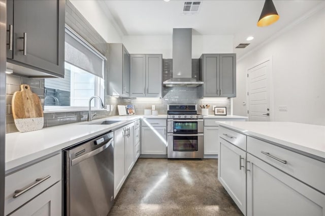 kitchen featuring sink, wall chimney exhaust hood, gray cabinets, tasteful backsplash, and stainless steel appliances