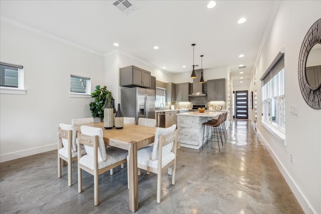 dining room with crown molding and concrete flooring