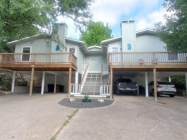 rear view of property with a carport and a deck