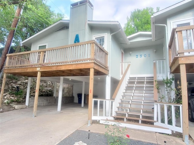 back of property with a deck and a patio area