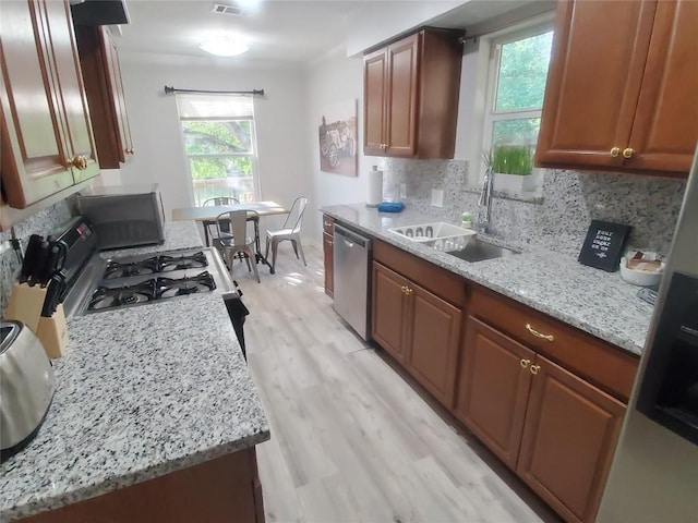 kitchen featuring stainless steel dishwasher, backsplash, a healthy amount of sunlight, and sink