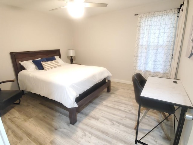 bedroom with ceiling fan, multiple windows, and light hardwood / wood-style flooring