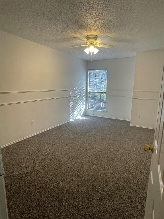 carpeted spare room with a textured ceiling and ceiling fan