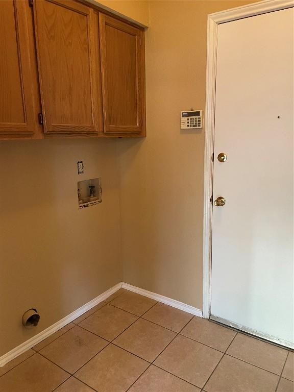 washroom featuring cabinets, hookup for a washing machine, and light tile patterned floors